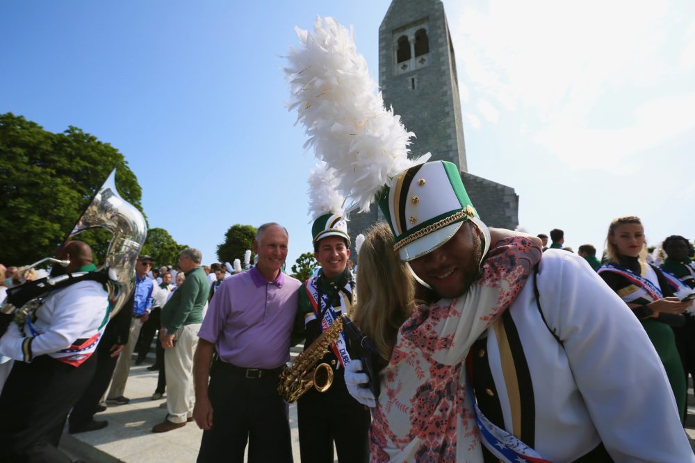 Lisa Dubois embraces UNC Charlotte student Tyriq Evans, of Winston-Salem, as Chancellor Phil Dubois looks on. Evans had just delivered remarks during a commemoration of D-Day and the World War II battle for Europe at the Brittany American Cemetery in Normandy, France.